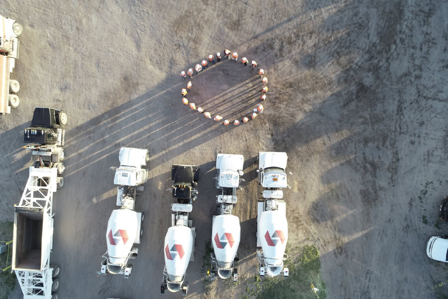Drone shot with 4 simon trucks and workers in circle. 